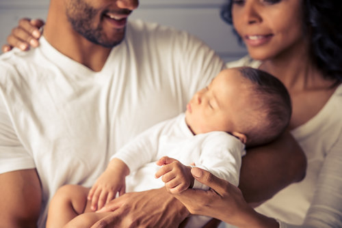 Parents holding their sleeping baby